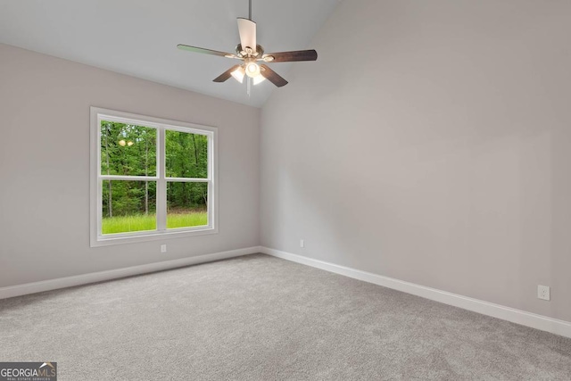 spare room with lofted ceiling, a ceiling fan, carpet flooring, and baseboards