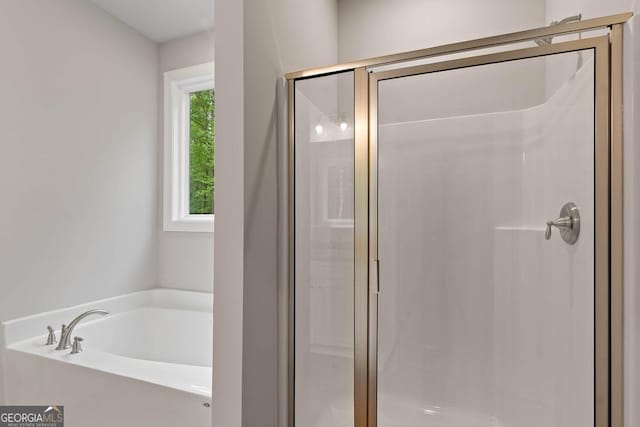 bathroom featuring a shower stall and a bath