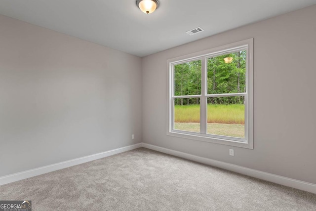 carpeted empty room featuring visible vents and baseboards