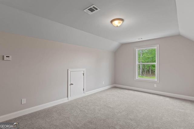 bonus room featuring lofted ceiling, carpet, visible vents, and baseboards