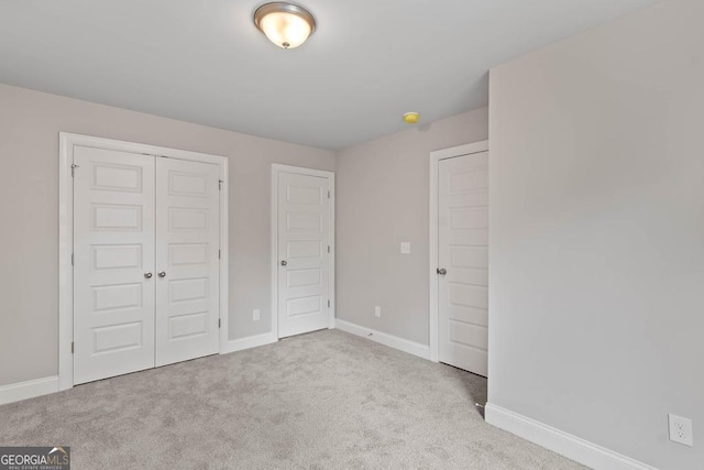 unfurnished bedroom featuring a closet, carpet floors, and baseboards