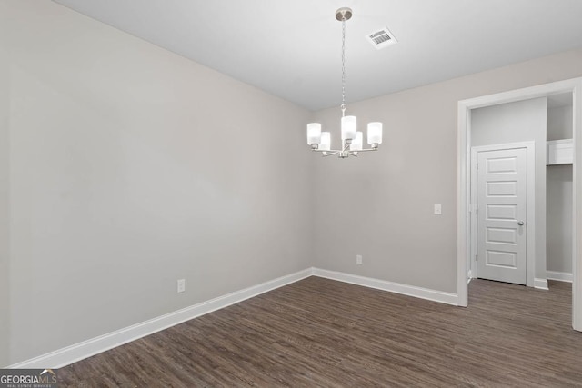 unfurnished room featuring a chandelier, visible vents, dark wood finished floors, and baseboards