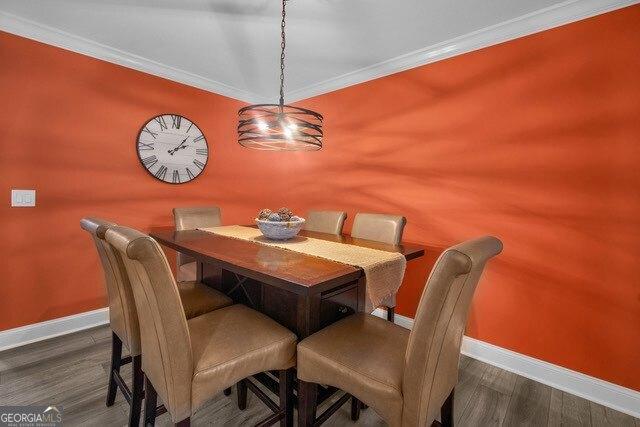 2508 Demere Rd Unit 2, Saint Simons, GA 31522 - dining room featuring baseboards, wood finished floors, and crown molding