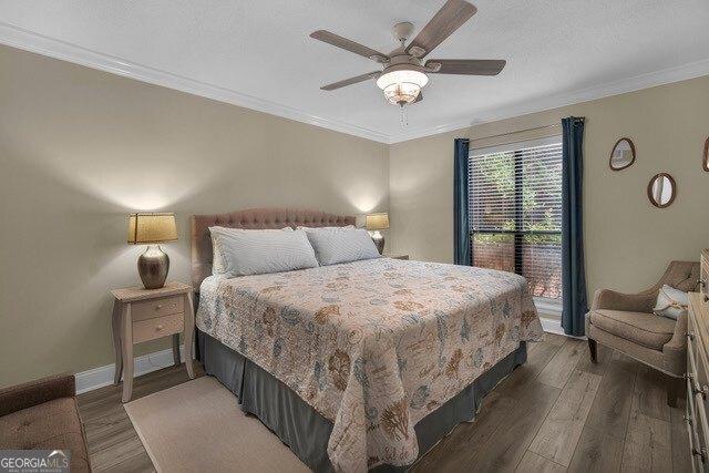 2508 Demere Rd Unit 2, Saint Simons, GA 31522 - bedroom with wood finished floors, ceiling fan, and crown molding