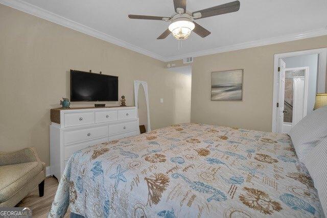2508 Demere Rd Unit 2, Saint Simons, GA 31522 - bedroom with visible vents, wood finished floors, a ceiling fan, and crown molding