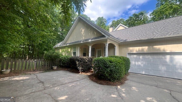169 Cambridge Way, Macon, GA 31220 - view of front facade featuring stucco siding, driveway, a garage, a chimney, and a shingled roof