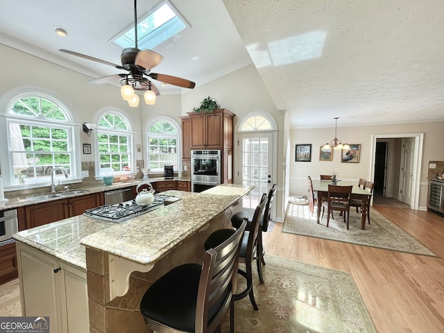 4614 Capers Xing W, Peachtree Corners, GA 30092 - kitchen with a sink, a textured ceiling, a healthy amount of sunlight, and stainless steel appliances