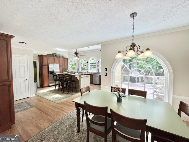 4614 Capers Xing W, Peachtree Corners, GA 30092 - dining area featuring light wood-type flooring, crown molding, a textured ceiling, and ceiling fan with notable chandelier