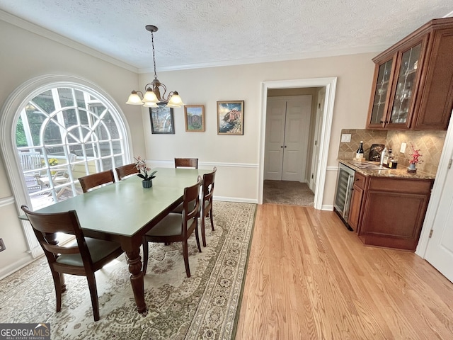 4614 Capers Xing W, Peachtree Corners, GA 30092 - dining area featuring a textured ceiling, beverage cooler, a chandelier, light wood-style floors, and bar area