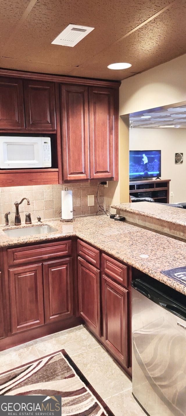 4614 Capers Xing W, Peachtree Corners, GA 30092 - kitchen with visible vents, dishwasher, white microwave, a sink, and backsplash