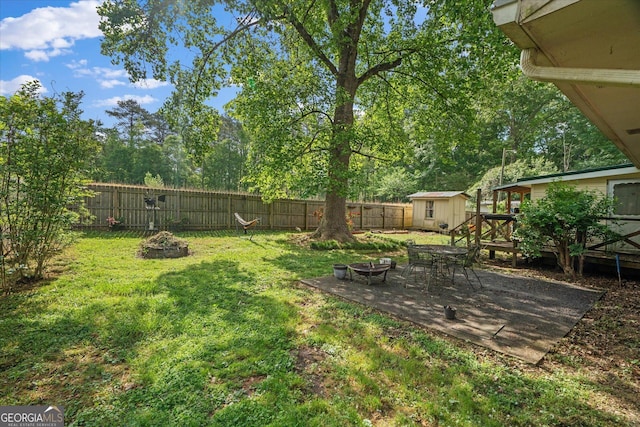 235 Castlegate Cir, Carrollton, GA 30116 - view of yard featuring a deck, a shed, an outbuilding, an outdoor fire pit, and a fenced backyard