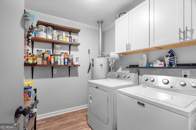 235 Castlegate Cir, Carrollton, GA 30116 - laundry area featuring water heater, light wood-style floors, cabinet space, washing machine and clothes dryer, and baseboards