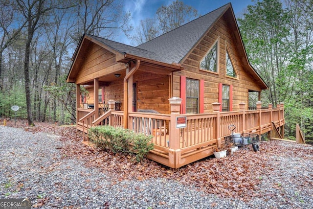 view of property exterior with roof with shingles and a deck