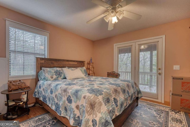 bedroom with access to exterior, ceiling fan, wood finished floors, and multiple windows