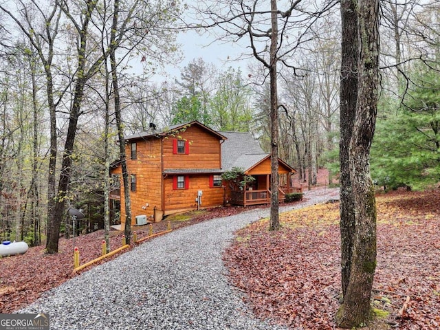 view of side of home with driveway and a porch