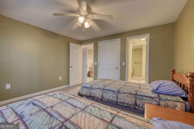 bedroom with carpet flooring, ceiling fan, ensuite bath, baseboards, and a textured ceiling