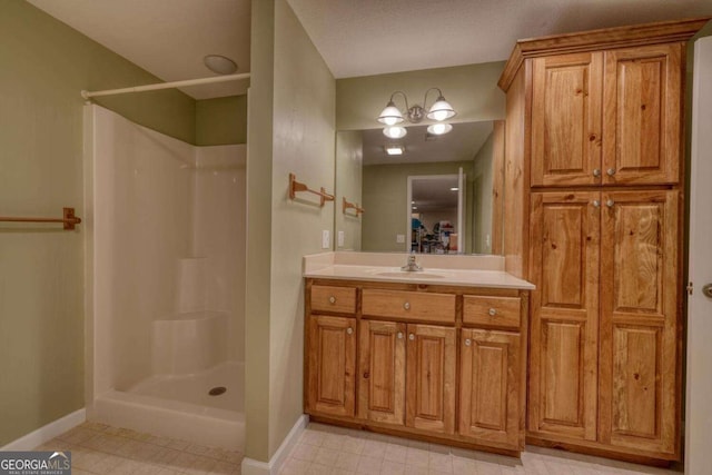full bath featuring a shower stall, vanity, and baseboards