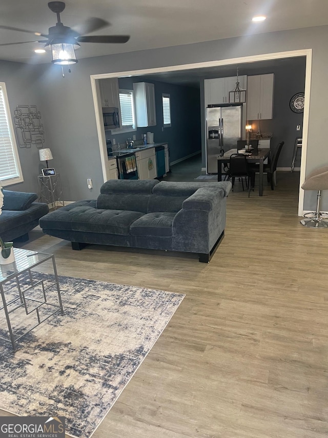 1962 Markone St NW, Atlanta, GA 30318 - living room featuring light wood finished floors, a ceiling fan, and baseboards