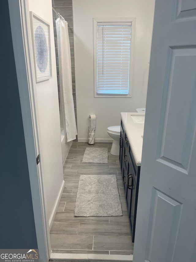 1962 Markone St NW, Atlanta, GA 30318 - bathroom featuring shower / tub combo, baseboards, toilet, wood finish floors, and vanity