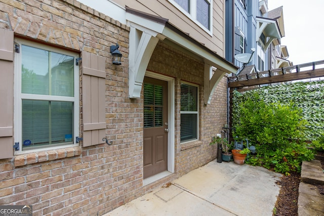 569 Mirrormont Dr SE, Smyrna, GA 30080 - view of exterior entry featuring brick siding, a patio, and a pergola