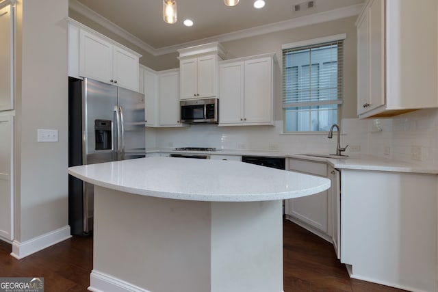 569 Mirrormont Dr SE, Smyrna, GA 30080 - kitchen with appliances with stainless steel finishes, dark wood finished floors, ornamental molding, tasteful backsplash, and white cabinets