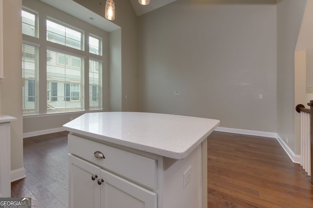 569 Mirrormont Dr SE, Smyrna, GA 30080 - kitchen with dark wood-style flooring, white cabinets, a center island, light stone countertops, and hanging light fixtures