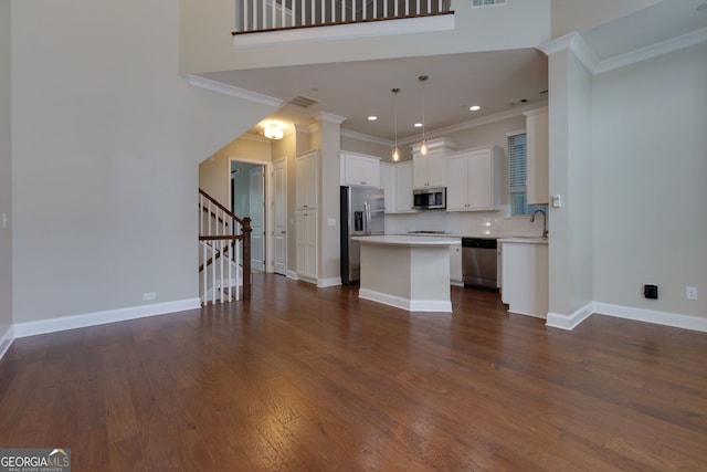 569 Mirrormont Dr SE, Smyrna, GA 30080 - kitchen featuring stainless steel appliances, a kitchen island, ornamental molding, light countertops, and white cabinets