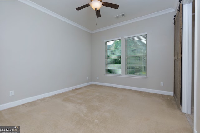 569 Mirrormont Dr SE, Smyrna, GA 30080 - spare room featuring ornamental molding, a ceiling fan, a barn door, and light carpet