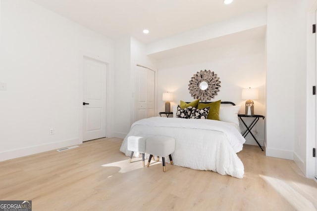 bedroom with baseboards, recessed lighting, wood finished floors, and visible vents