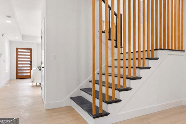stairway featuring baseboards, recessed lighting, and wood finished floors