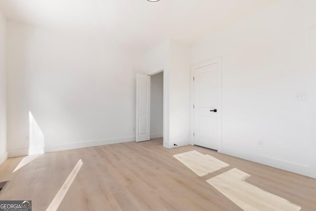 unfurnished room with baseboards and wood finished floors