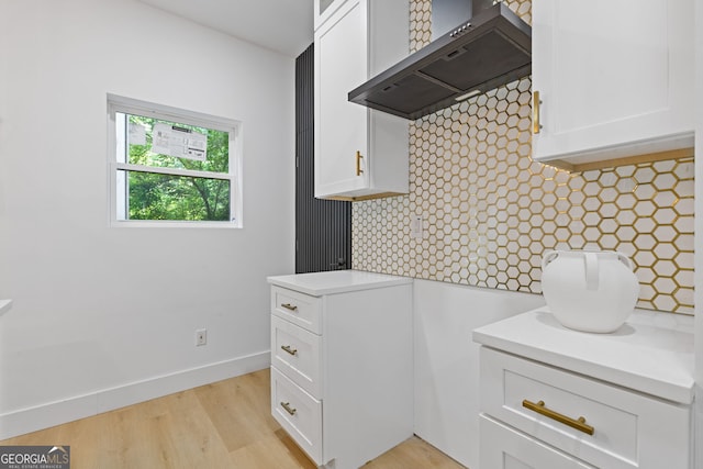 906 Mcdaniel St, Atlanta, GA 30310 - kitchen featuring custom range hood, white cabinetry, light countertops, light wood finished floors, and tasteful backsplash