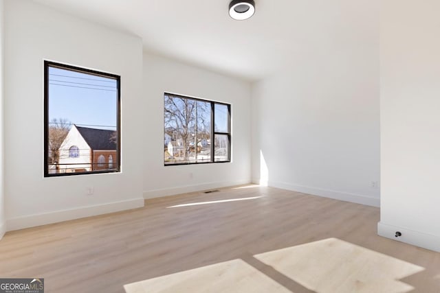 unfurnished room with baseboards and wood finished floors