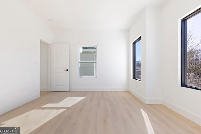 empty room featuring baseboards and wood finished floors
