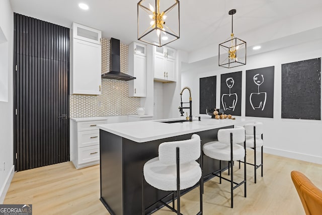 906 Mcdaniel St, Atlanta, GA 30310 - kitchen with a sink, wall chimney range hood, white cabinetry, an island with sink, and decorative backsplash