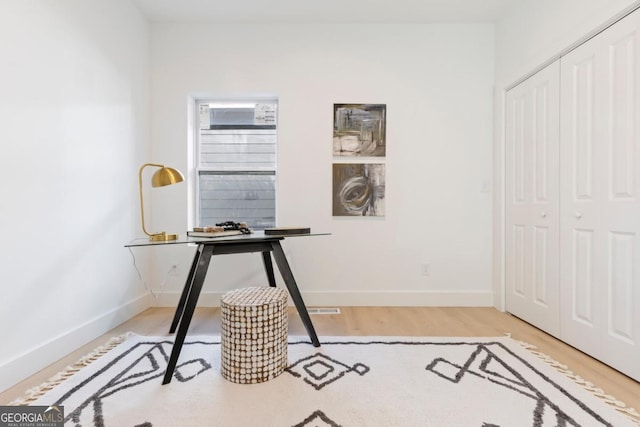 office area with baseboards and wood finished floors