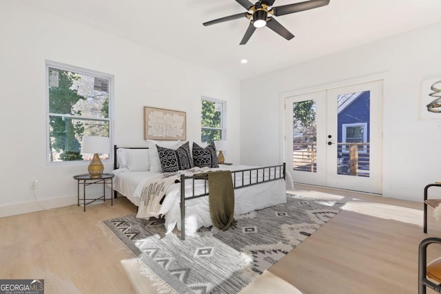 bedroom featuring access to outside, multiple windows, french doors, and wood finished floors
