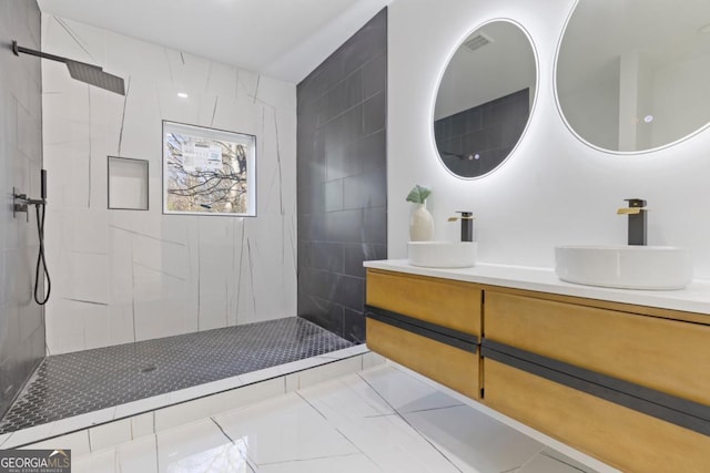 full bathroom with a walk in shower, double vanity, visible vents, and a sink