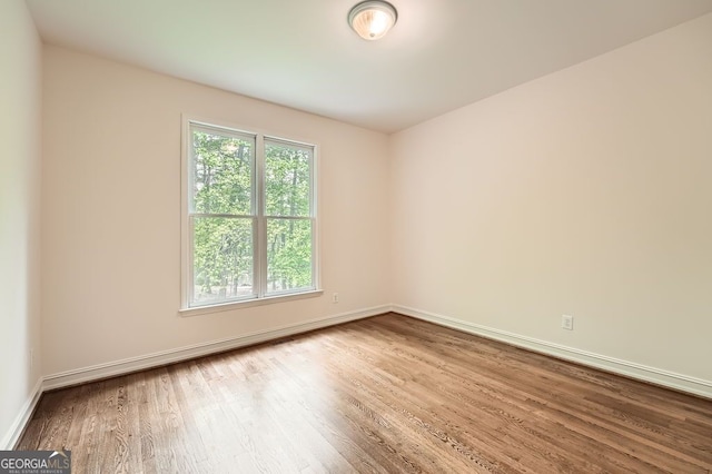 unfurnished room with baseboards and wood finished floors