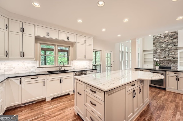 kitchen featuring a center island, a sink, wine cooler, and light wood-type flooring