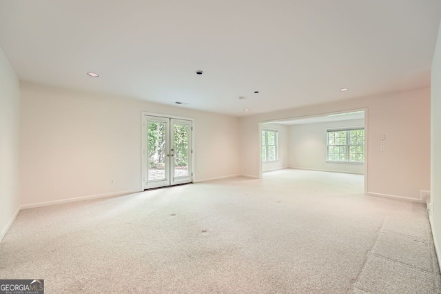 empty room featuring french doors, visible vents, light colored carpet, baseboards, and recessed lighting