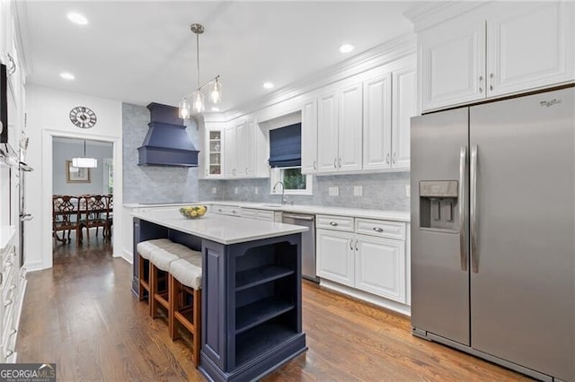 100 Barnard Pl, Atlanta, GA 30328 - kitchen with stainless steel appliances, custom range hood, light countertops, white cabinets, and a sink