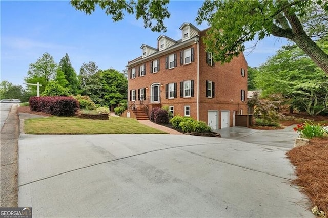 100 Barnard Pl, Atlanta, GA 30328 - view of front of property featuring concrete driveway, a garage, a front lawn, and brick siding