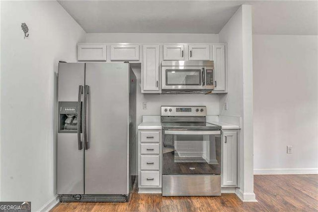 460 Broad St, Tallapoosa, GA 30176 - kitchen with appliances with stainless steel finishes, dark wood-style flooring, light countertops, and white cabinets