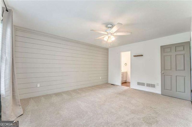 460 Broad St, Tallapoosa, GA 30176 - unfurnished bedroom featuring carpet, ensuite bathroom, ceiling fan, and wooden walls