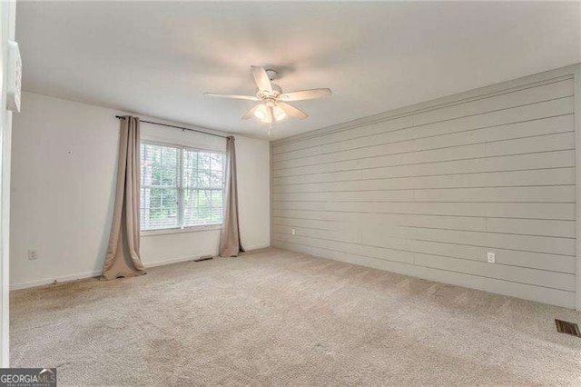 460 Broad St, Tallapoosa, GA 30176 - unfurnished room with ceiling fan, light carpet, and wood walls