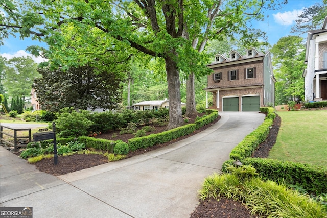 view of front facade with a garage, driveway, brick siding, and a front yard