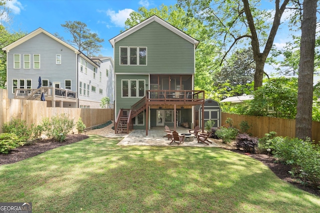 rear view of property featuring a patio, a shed, a sunroom, stairs, and an outdoor fire pit