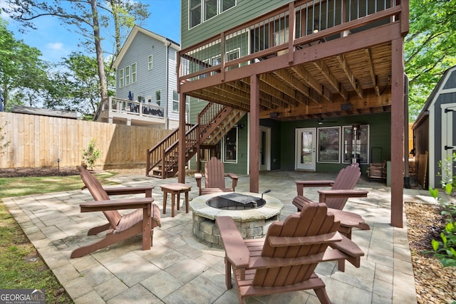 view of patio featuring fence, a deck, a fire pit, and stairway