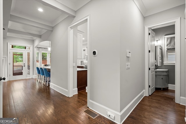 corridor featuring visible vents, arched walkways, dark wood finished floors, and baseboards